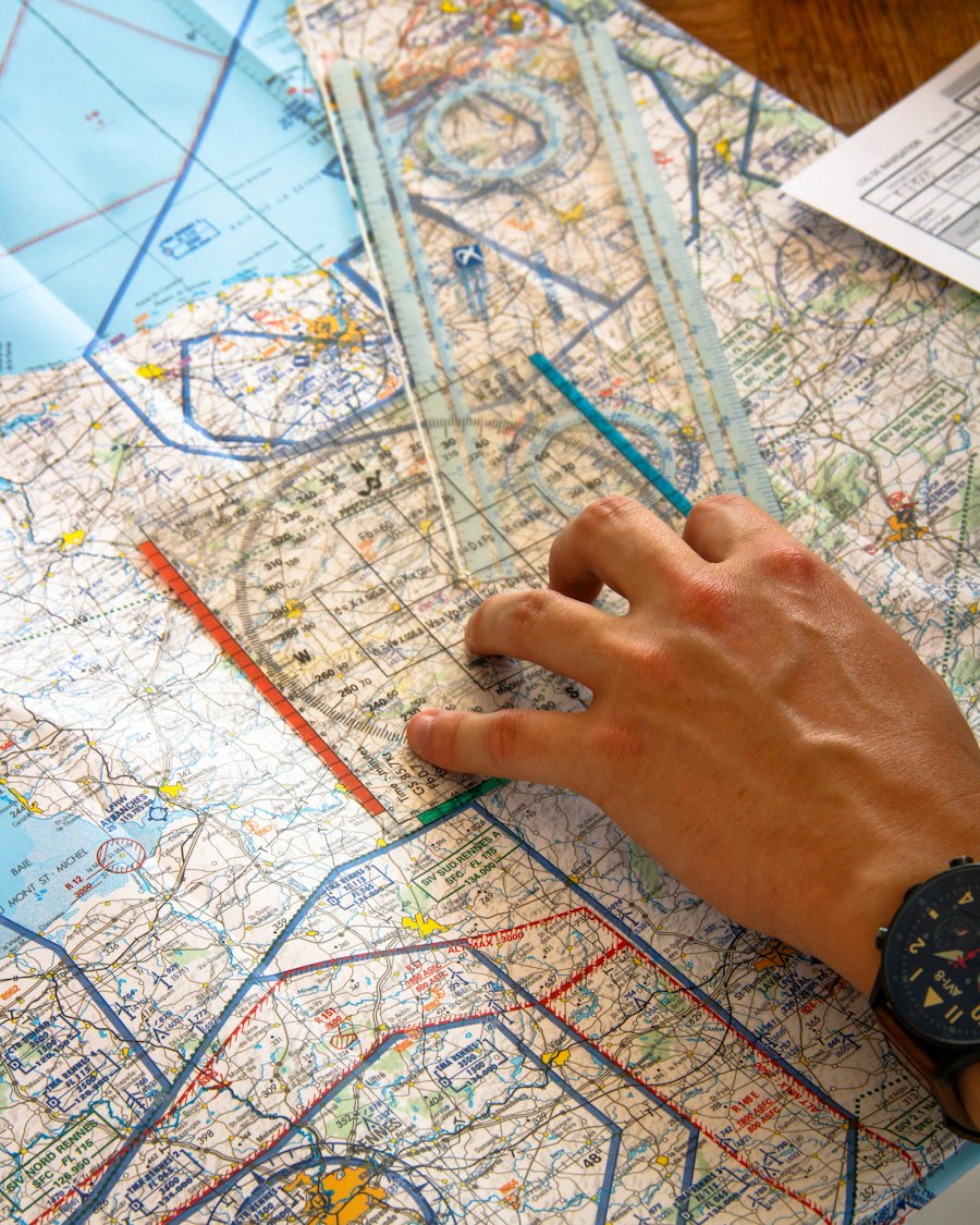 Hand using a ruler to plot a route on an aviation chart.